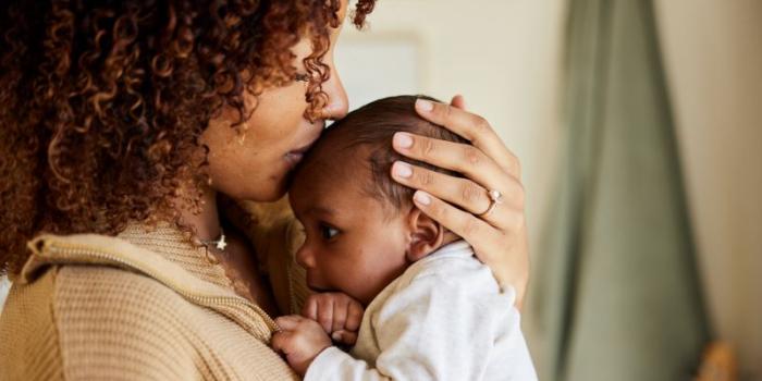 Mother kissing her child.